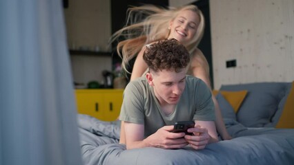 Young happy couple in love lying in bed in morning in their new home in tiny house, sustainable living concept.