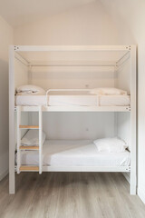 Fototapeta na wymiar White bunk beds with stairs, in a white room 