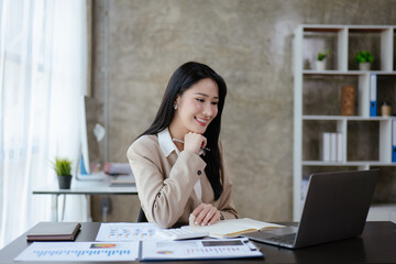 Young business women working and thinking on laptop with happy and smile face on office spec.