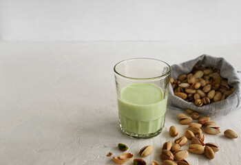 Pistachio milk in the glass  on the white background. This milk is a great source of antioxidants, phytosterols, and heart healthy fats
