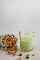 Pistachio milk in the glass  on the white background. This milk is a great source of antioxidants, phytosterols, and heart healthy fats