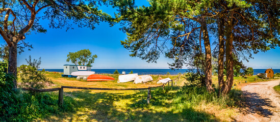 Panorama. Countryside landscape with old anchored fishing boats, village of fishermen on a beach of...