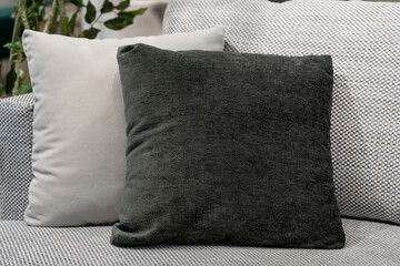 Close up light grey fabric sofa with warm cozy home interior background. Pillows on gray sofa room decoration background