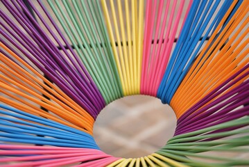 ein bunter stuhl zum entspannen mit bunten seilen bespannt, regenbogenfarben