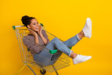 Full size photo of positive crazy lady sit trolley astonished reaction isolated on yellow color...