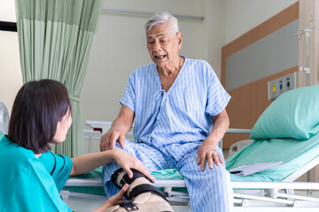 Obraz premium An Asian surgeon in Thailand meets an elderly patient who has undergone surgery to inquire about the condition and check the health of a patient lying on a hospital bed.
