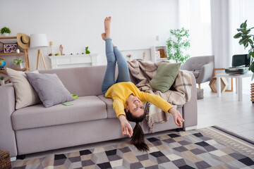 Full body portrait of satisfied glad person laying upside down sofa toothy smile house indoors