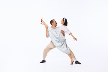 Portrait of young beautiful couple, man and woman, dancing isolated over white studio background. Twine