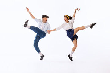 Portrait of beautiful couple, man and woman, dancing retro dance isolated over white studio...