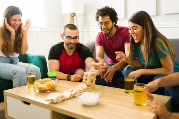 Happy friends enjoying playing a fun board game while hanging out