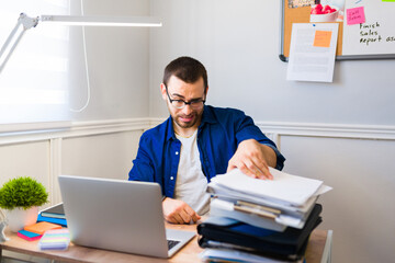 Fototapeta premium Stressed man with a lot of work to do while telecommuting