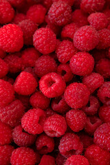 Ripe juicy raspberries close-up. Background from raspberries. Summer delicious sweet berry. Texture of raspberry macro photo. Healthy organic food, vitamins. Raspberry harvest