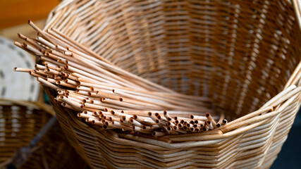 Obraz premium Handmade basket made of brown paper tubes. Rustic basket with rolled paper tubes. Texture of a braided pattern from eco vines. Basket weaving background. Creativity, art, handwork, hobby. Close up.