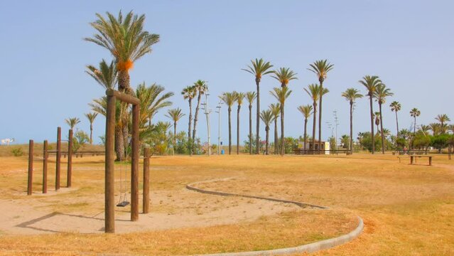 Panorama Of Sports Area And Public Park With Palm Trees Near Beach In Castellon, Spain. wide pan right