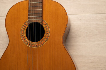 Obraz premium Classical guitar body close up, on a light wood background with copy space. 