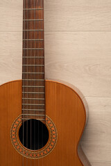 Fototapeta na wymiar Classical guitar body close up, on a light wood background with copy space. 