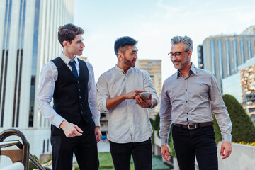 Young businessmen with mentor outdoors