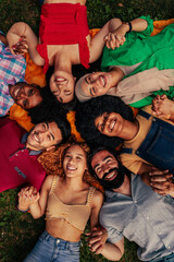 Smiling young adults in circle on grass