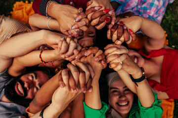 Friends lying on grass holding hands