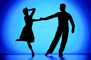 Black silhouettes of dance partners performing Argentine tango. Man and woman are dancing choreography elements on blue gradient background. Screensaver for school of ballroom Latin American dances.