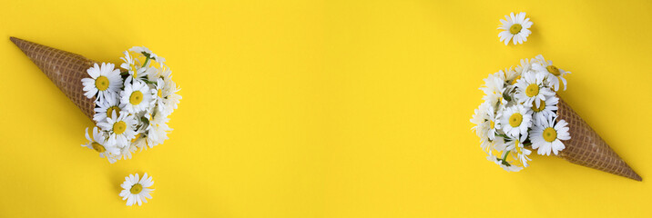 Summer banner. Ice cream cone with chamomiles on the yellow background. Copy space.
