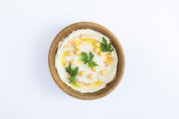 Top view of hummus in the brown wooden  bowl on the white background. Closeup.