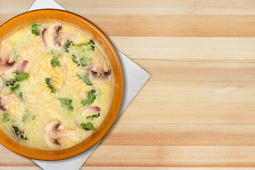 Soup in brown bowl on stone table.