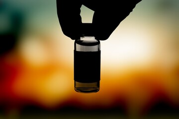Vaccine concept. Medical hand black silhouette showing bottle with vaccine.