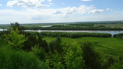 Landscapes of Siberia. Beautiful summer landscape on a powerful river immersed in green banks.  Grove, meadow and floodplain of the Siberian river Irtysh.