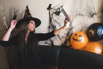 A young woman makes a scary face at the camera in her phone. The concept of congratulations online...
