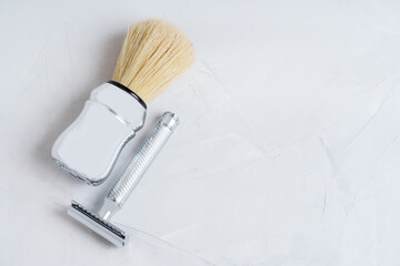 Safety razor and shaving brush on a concrete table