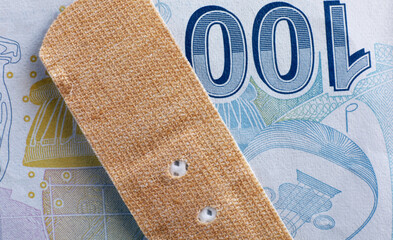 Close-up band-aid on Turkish paper money
