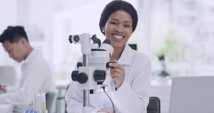 Portrait of scientist using a microscope in a lab to analyze medical samples. Happy black woman smiling while doing experiments to develop a cure. Microbiologist feeling confident about her research