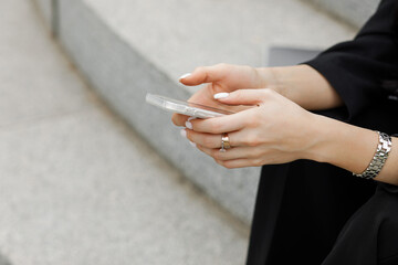 Fototapeta premium Female hands holding a smartphone, close up