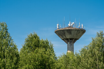 Concrete water supply tower with various telecommunication antennas.