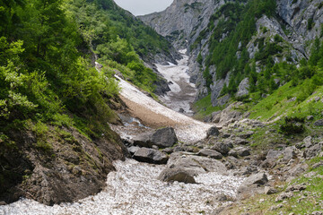 Fototapeta na wymiar Late Summer snow in the White Valley, an unmarked alpine route in Bucegi mountains, Romania.