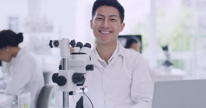 Chemist looking at medical samples while conducting experiment and collecting data. Handsome chemist discovering a cure. Portrait of leading scientist using microscope in busy lab to find a cure