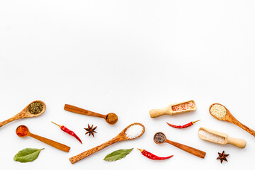 Layout of spices and herbs in wooden spoons, top view
