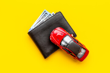 Purchase or rent a car concept. Toy car with wallet and money cash