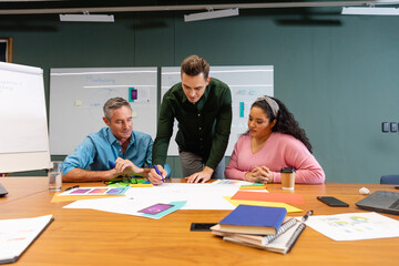 Multiracial businessmen and businesswoman discussing business strategy in meeting at creative office