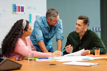 Fototapeta premium Businessman discussing business strategy with multiracial colleagues in meeting at creative office