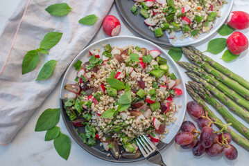 healthy summer salad with barley and asparagus on a table