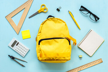 Flat lay of school backpack with school items and student accessories, top view