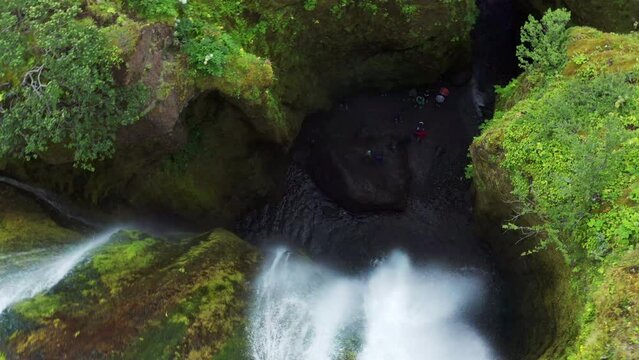 Descending into a Gljufrabui waterfall cave with Tourists down bellow - Iceland