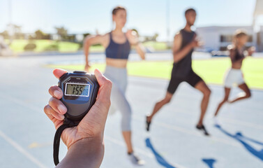 A sport coach timing athletes progress using a stopwatch. .Blurred athletes racing towards finish line and breaking the record. Stopwatch measuring time for a marathon at a sports event. - Powered by Adobe