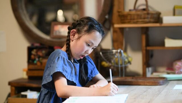 自宅で真剣に勉強をする少女