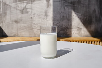 A glass of milk drink or yogurt on a white table. The concept of lactose intolerance. Transparent glass with tasty milk
