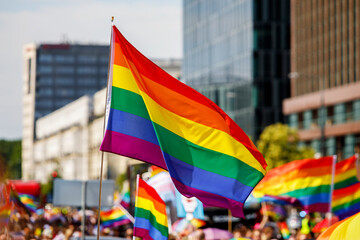 Lgbt pride rainbow flag during parade in the city . - obrazy, fototapety, plakaty
