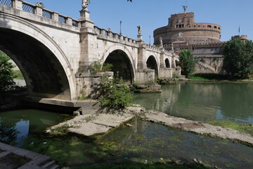 Obraz premium ROME JULY 5 32022 A VIEW OF THE TIBER RIVER NEVER SO LOW DUE TO DROUGHT. REMAINS OF AN ANCIENT COLLAPSED ROMAN BRIDGE EMERGED