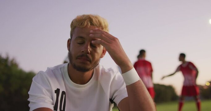 Video of mad biracial football player siting on field